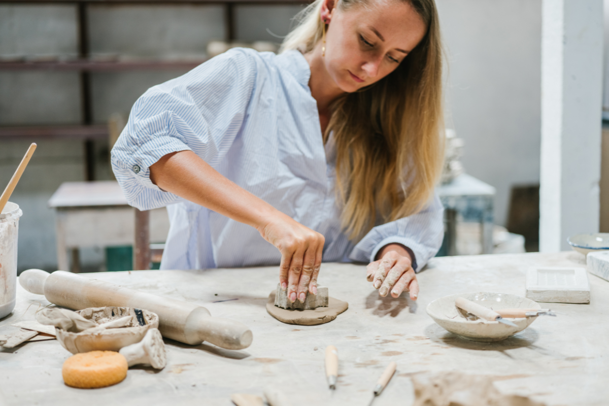 A woman focused on pottery, exploring creativity and craftsmanship as part of her journey in finding a hobby that brings joy and fulfillment.