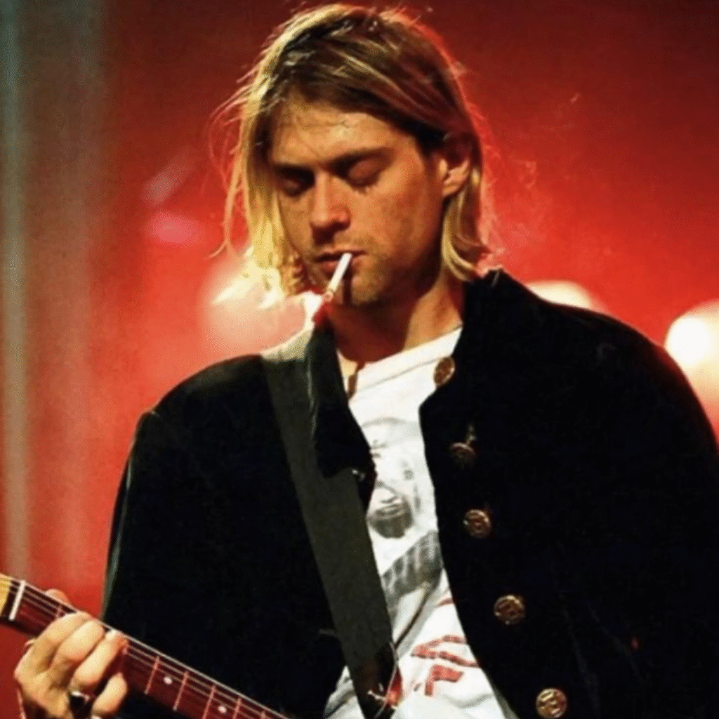 Kurt Cobain wearing classic 90s grunge fashion – flannel shirt and messy hair, symbol of grunge culture