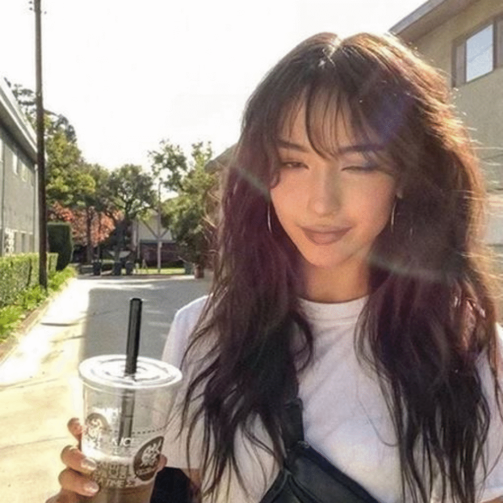 Alternative hairstyle with choppy bangs and teased grunge hair complemented by smudged makeup.
