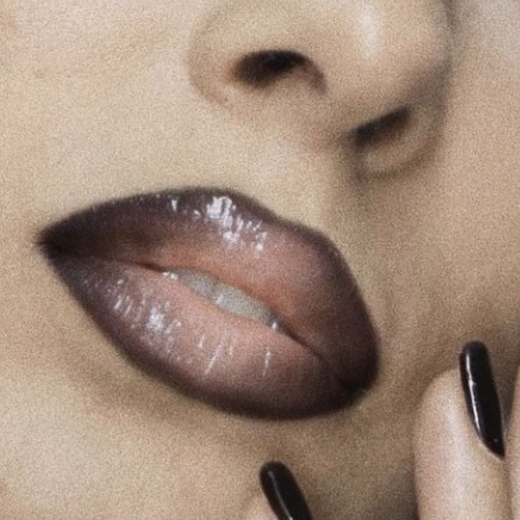Close-up portrait showing choppy bangs, tousled grunge hair, and deep plum dark lipstick.