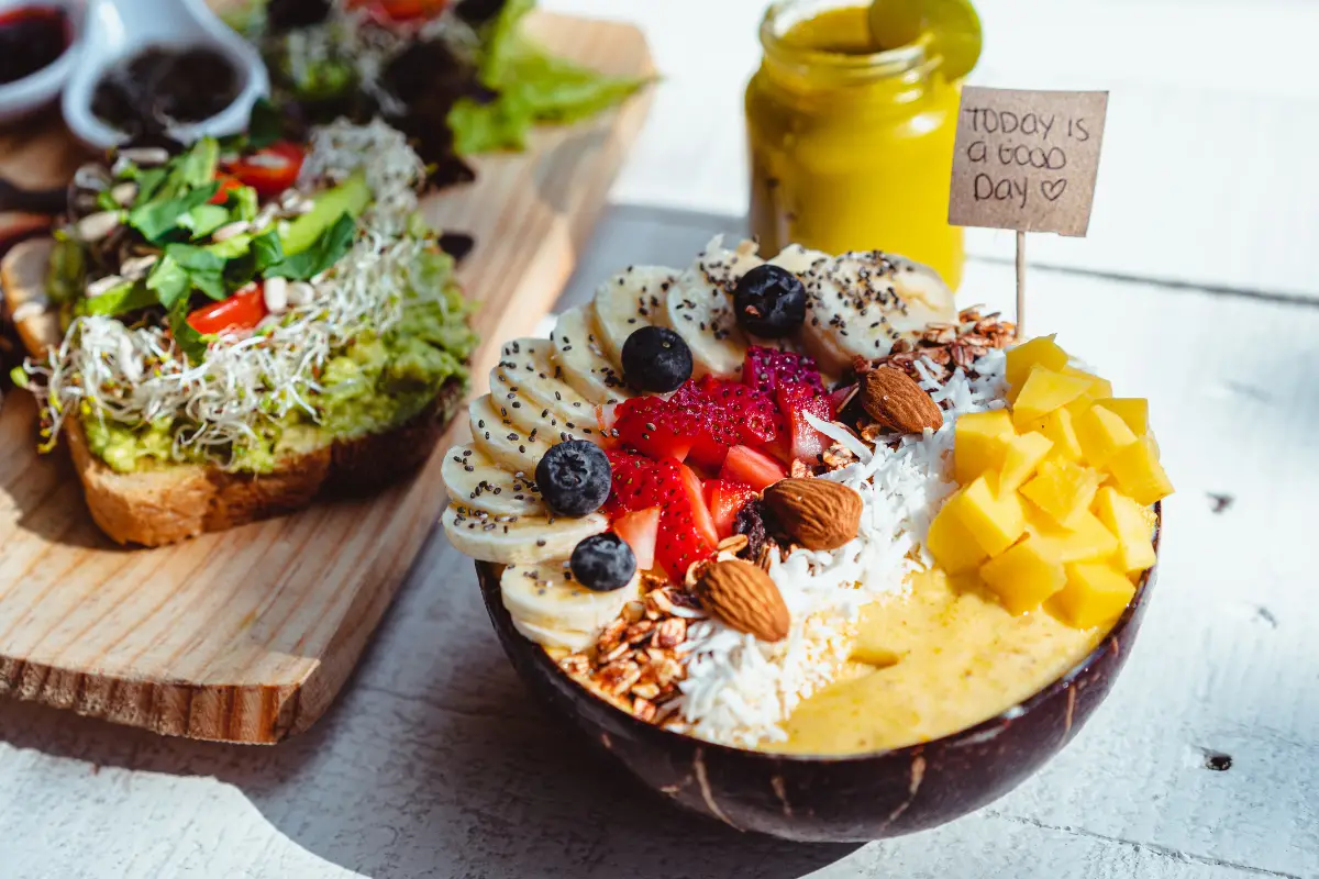 Acai bowl on a table with fresh fruit, granola, and a few ingredients nearby, showcasing a colorful, healthy, and nutritious breakfast option.