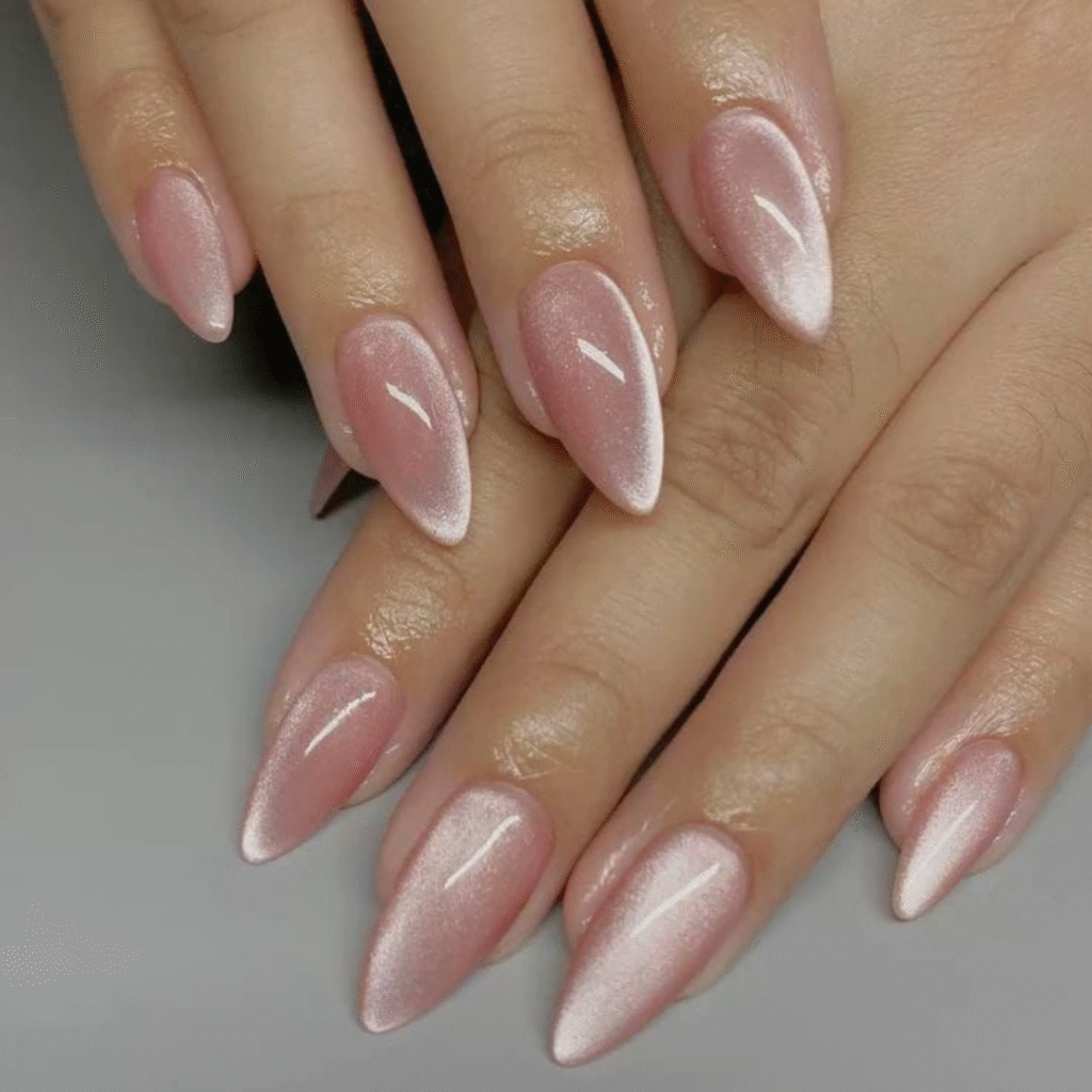 Soft pink cat eye nails with a subtle metallic glow and medium length.