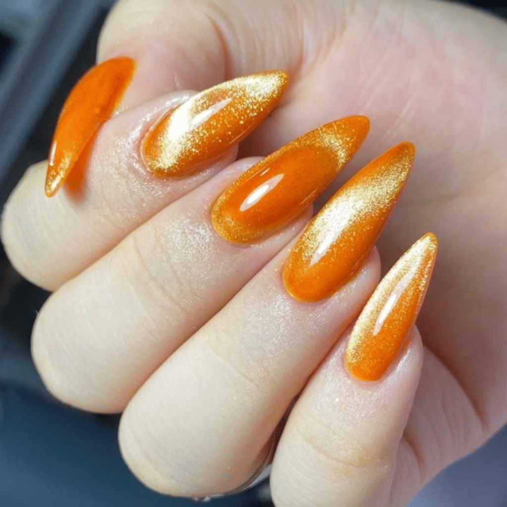 Long orange cat eye nails with metallic shimmer and rich golden glow that shifts beautifully under light.