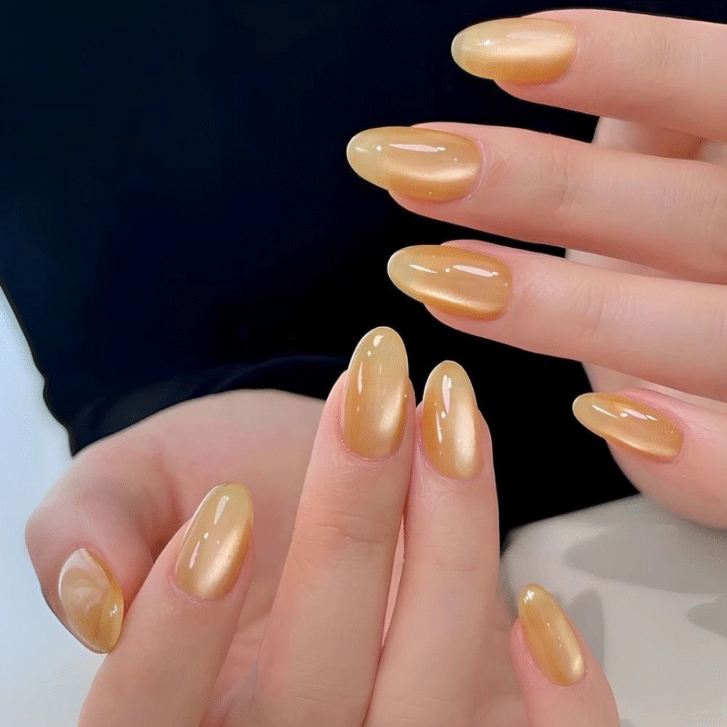 Soft yellow cat eye nails with a glossy, magnetic effect perfect for a cheerful look.