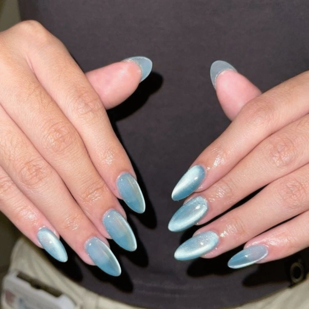 Medium blue cat eye nails with round tips and a glowing galaxy-like shine.