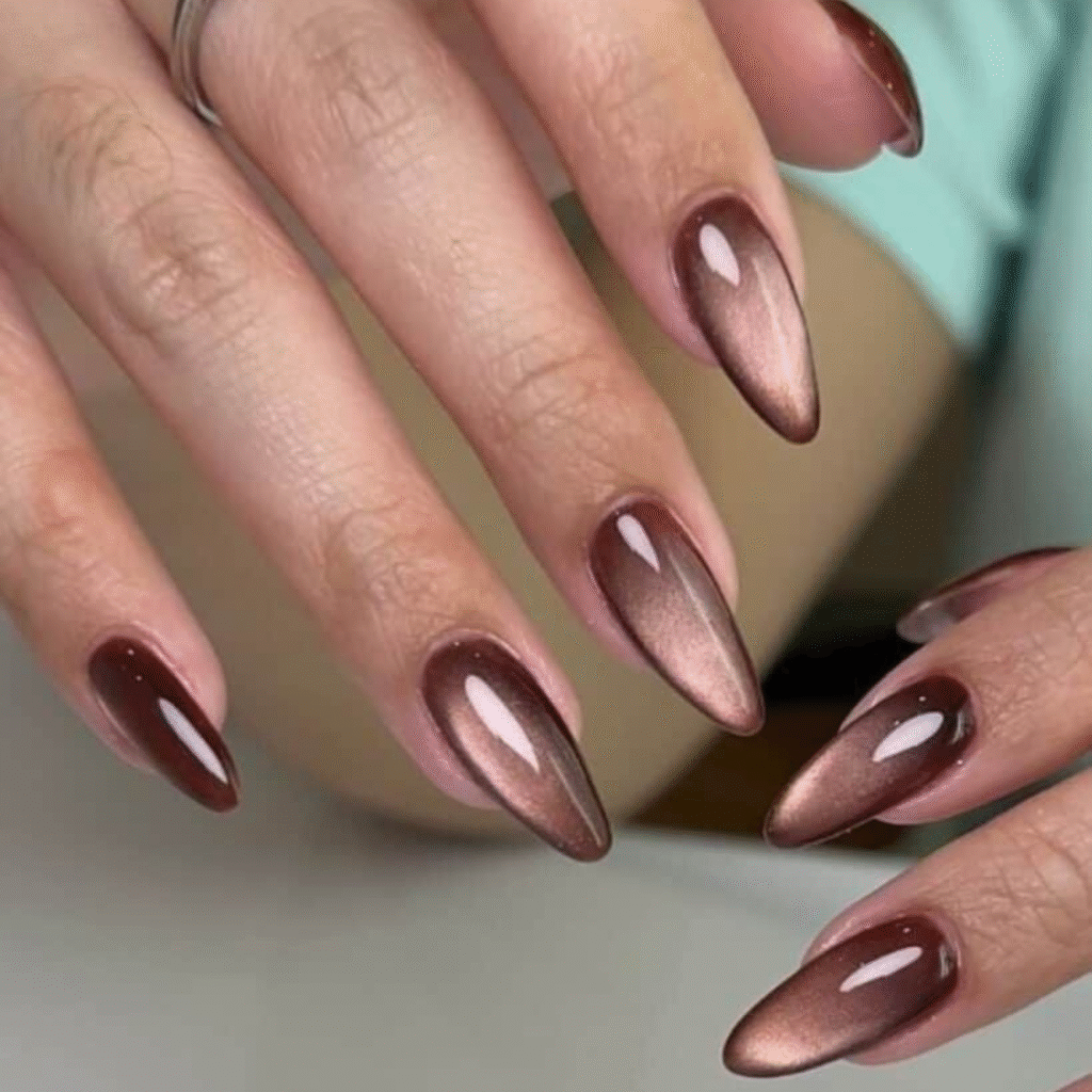 Long brown cat eye nails with translucent shine and subtle magnetic depth.