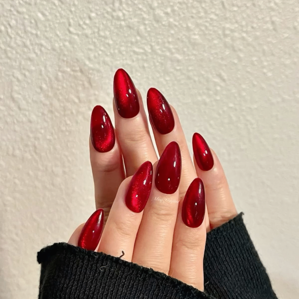 Deep red cat eye nails with a smooth glossy shine and striking magnetic depth.