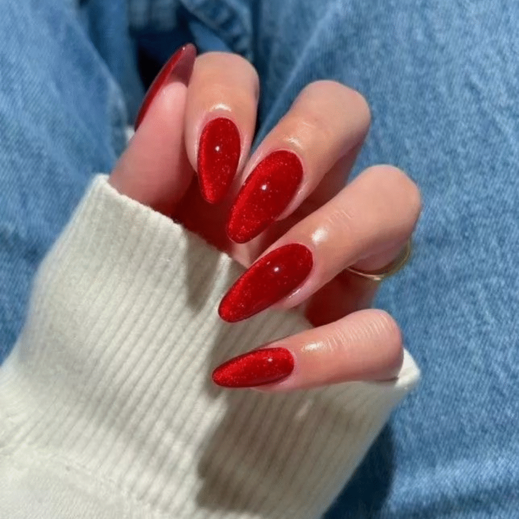 Long red cat eye nails with a fiery magnetic glow and high-gloss finish.