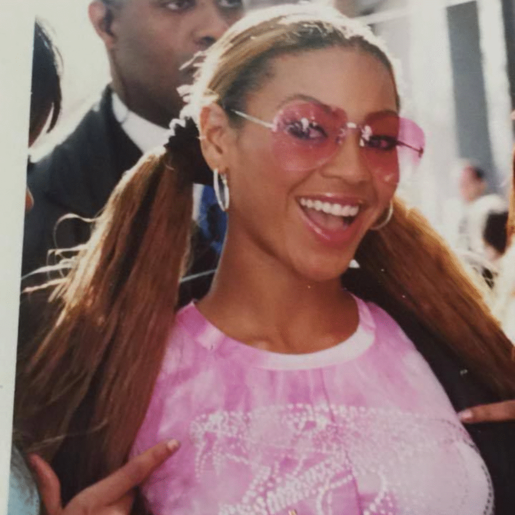 Beyoncé in Y2K glasses paired with glossy pink Y2K makeup and a matching pink top.